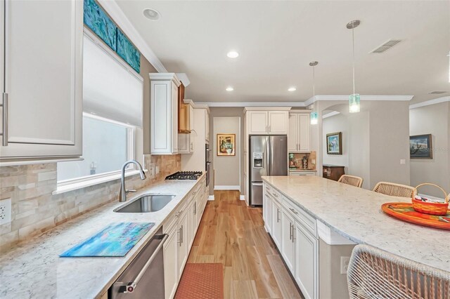 kitchen with pendant lighting, light stone counters, tasteful backsplash, a kitchen bar, and stainless steel appliances