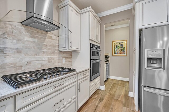 kitchen with decorative backsplash, light stone counters, white cabinets, stainless steel appliances, and extractor fan