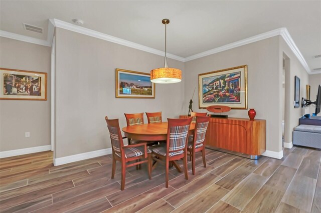 dining room featuring hardwood / wood-style flooring and crown molding