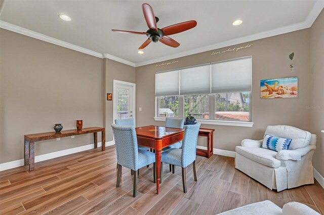 dining area with light hardwood / wood-style floors, ornamental molding, and ceiling fan