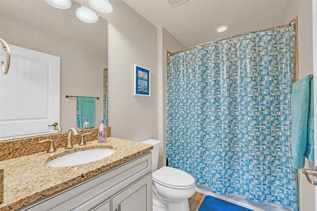 bathroom featuring vanity, toilet, and a shower with shower curtain