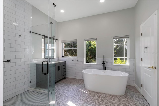 2228 Valrico Forest Dr, Valrico, FL 33594 - bathroom with plus walk in shower, tile walls, tile patterned flooring, lofted ceiling, and vanity