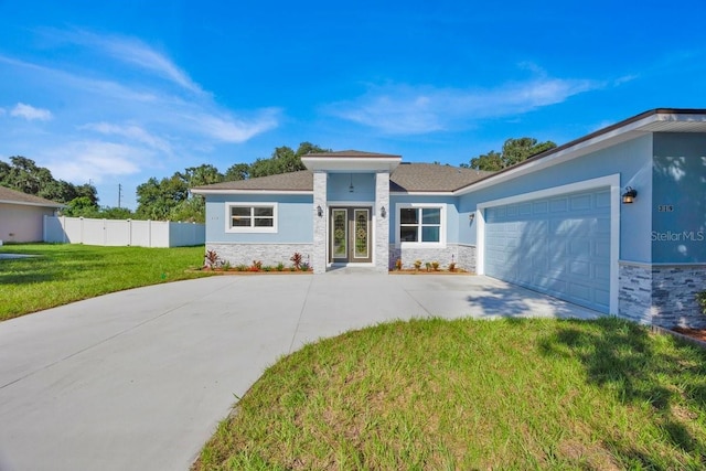 view of front of home with a garage and a front lawn