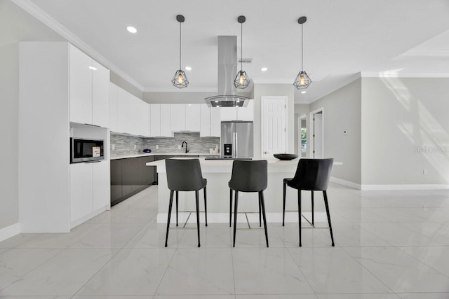 kitchen featuring white cabinets, tasteful backsplash, a kitchen island, island exhaust hood, and appliances with stainless steel finishes