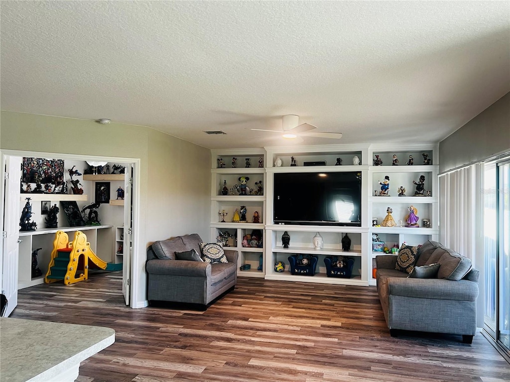 living room featuring a textured ceiling, ceiling fan, and dark hardwood / wood-style floors