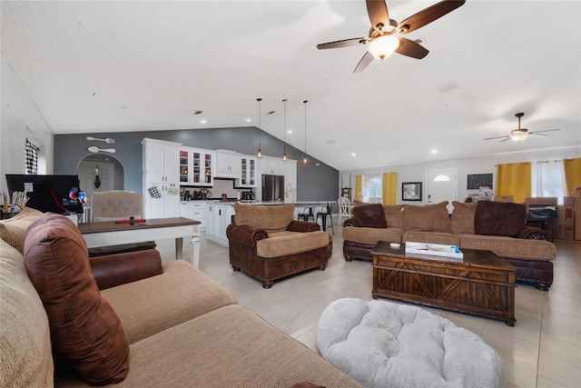 tiled living room with ceiling fan and vaulted ceiling