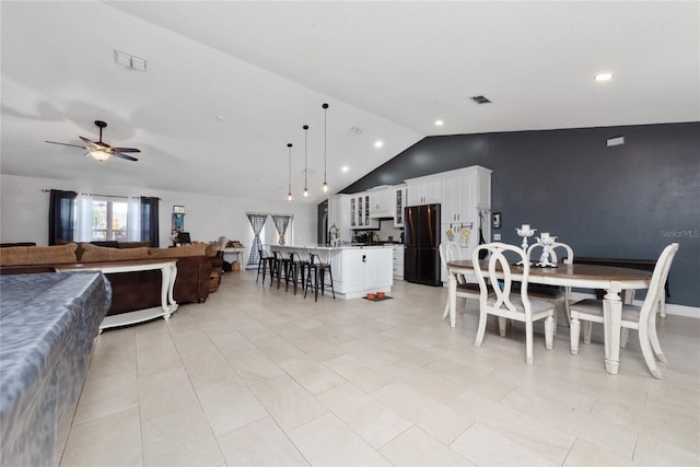 tiled dining space with lofted ceiling, ceiling fan, and sink