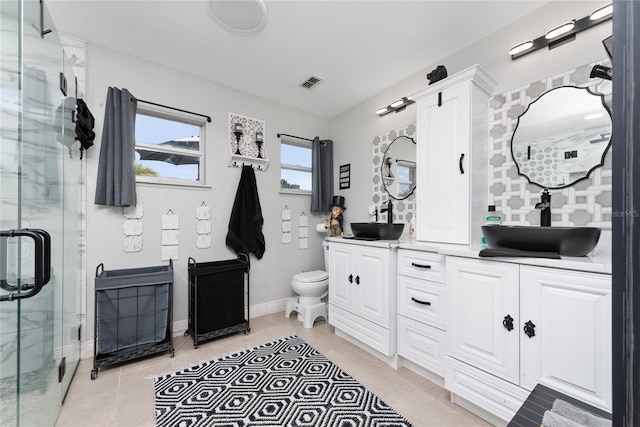 bathroom featuring walk in shower, vanity, toilet, and tile patterned floors