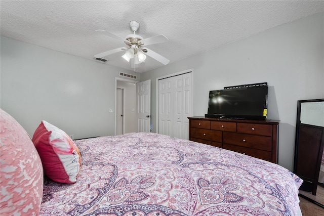 bedroom featuring a textured ceiling, carpet floors, ceiling fan, and a closet