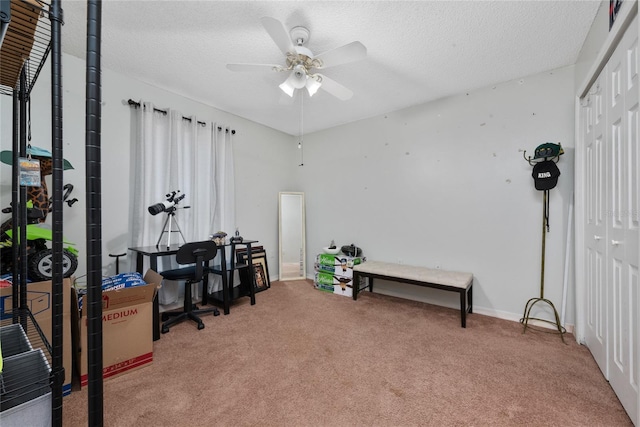 carpeted office space with ceiling fan and a textured ceiling