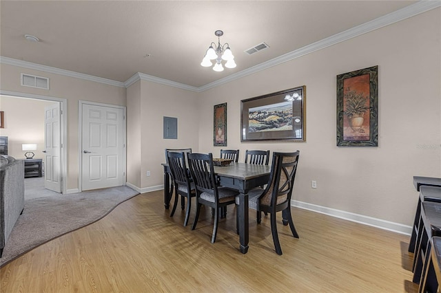 dining space with an inviting chandelier, light wood-type flooring, electric panel, and crown molding