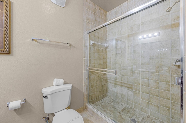 bathroom with a shower with door and toilet