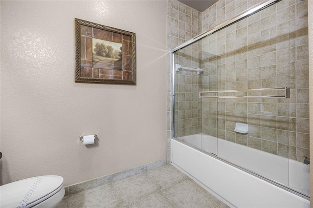 bathroom featuring combined bath / shower with glass door, toilet, and tile patterned floors