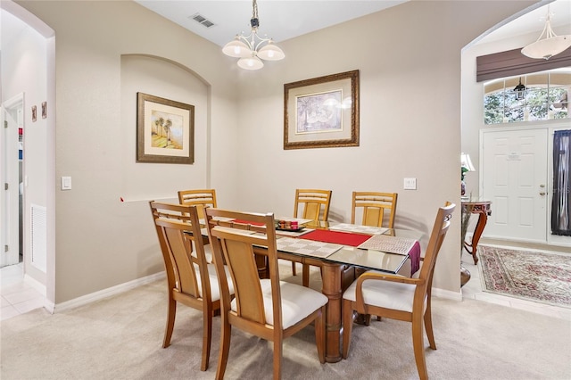 carpeted dining area featuring a chandelier