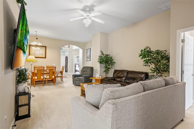 carpeted living room with ceiling fan