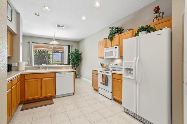 kitchen featuring hanging light fixtures, light tile patterned floors, sink, white appliances, and a textured ceiling