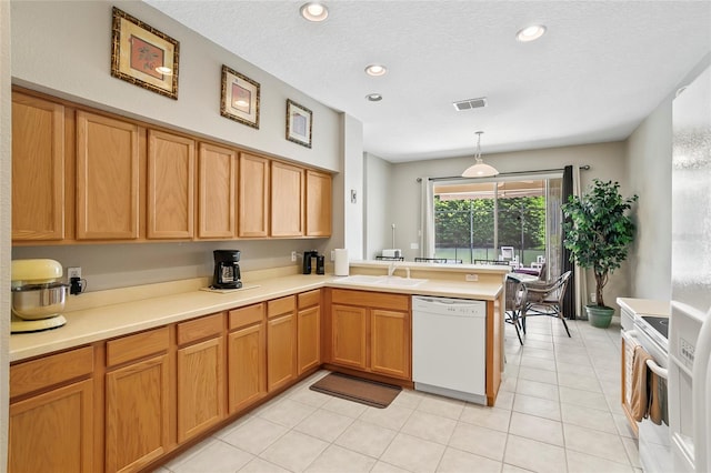 kitchen with pendant lighting, kitchen peninsula, light tile patterned floors, white dishwasher, and stainless steel range