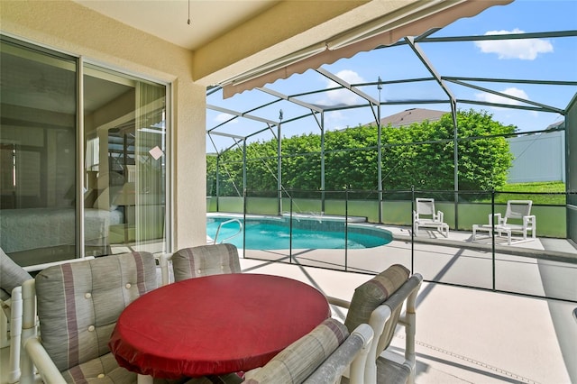 view of pool featuring glass enclosure, pool water feature, and a patio area