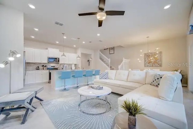 living room with ceiling fan with notable chandelier