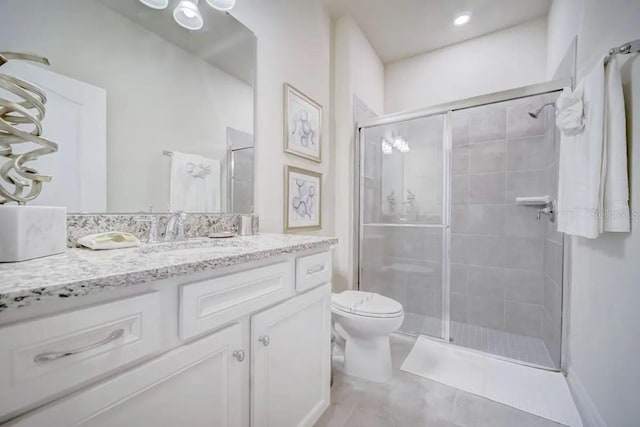 bathroom with vanity, toilet, and a shower with door