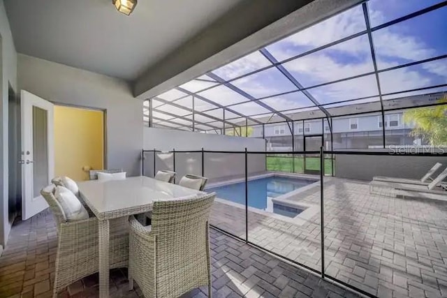 view of swimming pool featuring a lanai, a patio area, and a jacuzzi