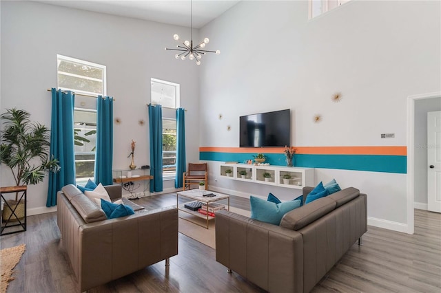 living room featuring light hardwood / wood-style floors, an inviting chandelier, and high vaulted ceiling