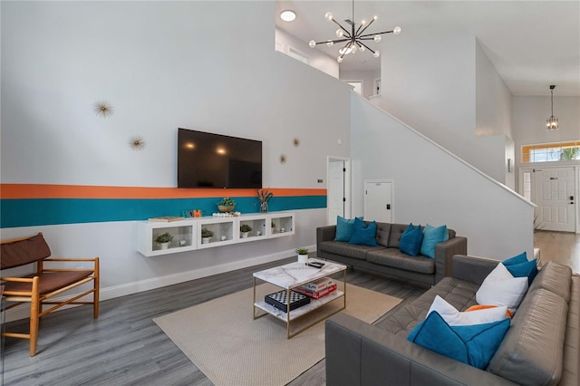 living room featuring an inviting chandelier, hardwood / wood-style floors, and high vaulted ceiling