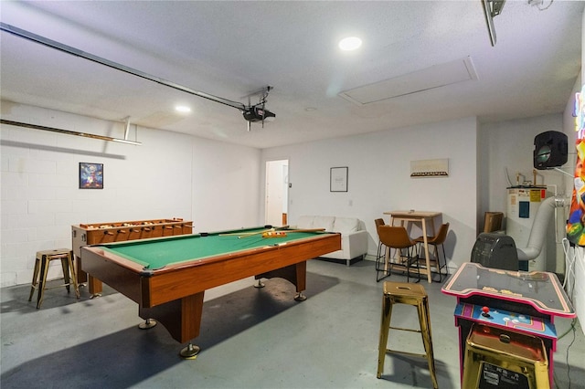 recreation room featuring pool table, water heater, and concrete flooring