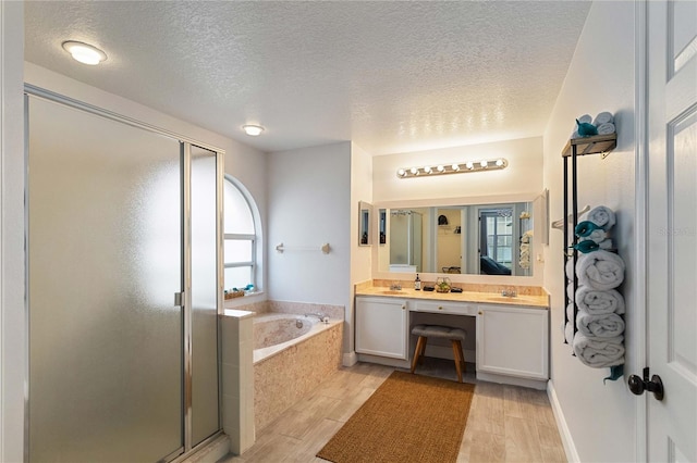 bathroom featuring vanity, separate shower and tub, a textured ceiling, and hardwood / wood-style flooring