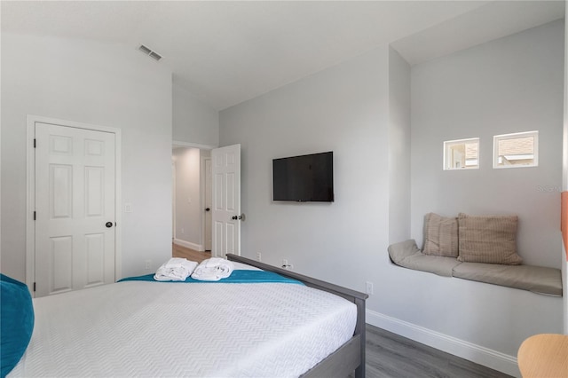 bedroom featuring lofted ceiling and dark hardwood / wood-style floors