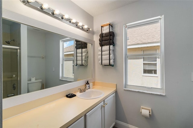 bathroom featuring walk in shower, vanity, and toilet