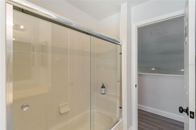 bathroom featuring combined bath / shower with glass door and hardwood / wood-style floors