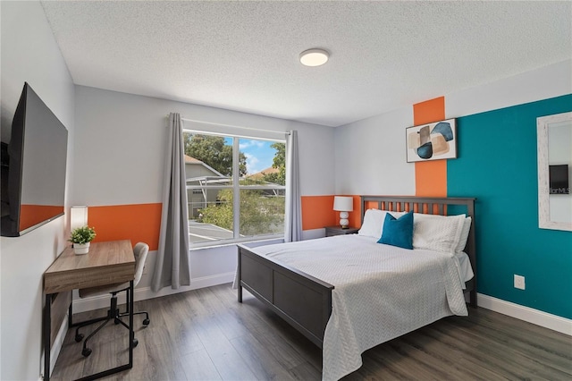 bedroom featuring a textured ceiling and dark hardwood / wood-style floors