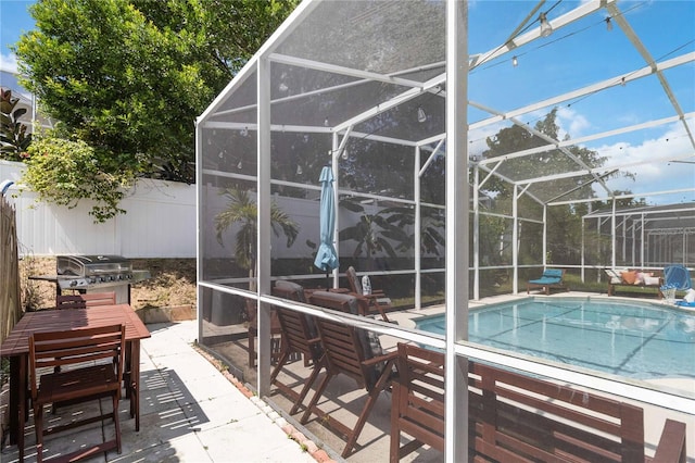 view of swimming pool with glass enclosure, area for grilling, and a patio area