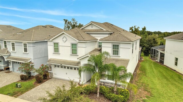 view of front of property featuring a front yard, a garage, and a lanai