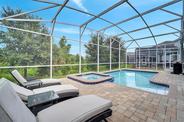 view of pool with a lanai, an in ground hot tub, and a patio