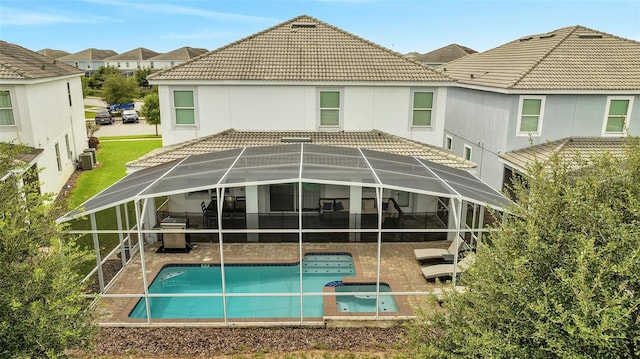 back of property with cooling unit, glass enclosure, and a patio area