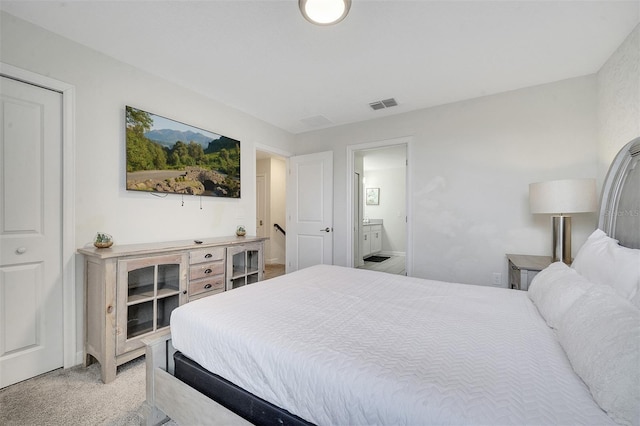 bedroom featuring light colored carpet and ensuite bathroom