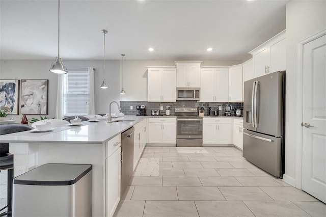 kitchen with pendant lighting, appliances with stainless steel finishes, sink, and white cabinetry