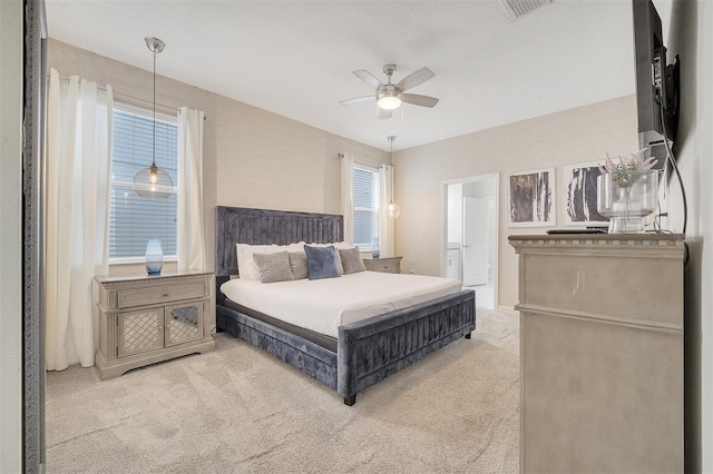 carpeted bedroom featuring ceiling fan and ensuite bathroom