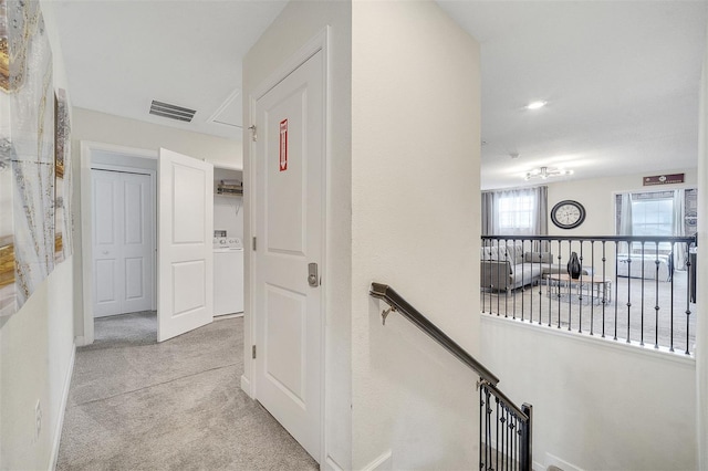 hall featuring light carpet and washer / clothes dryer