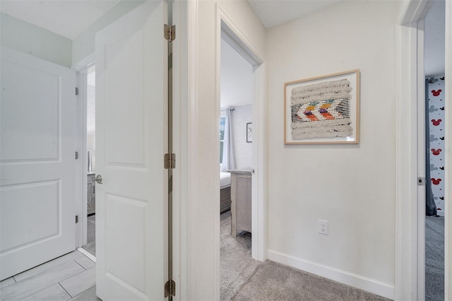 corridor with light colored carpet and a healthy amount of sunlight