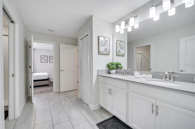 bathroom with tile patterned floors, vanity, and a textured ceiling