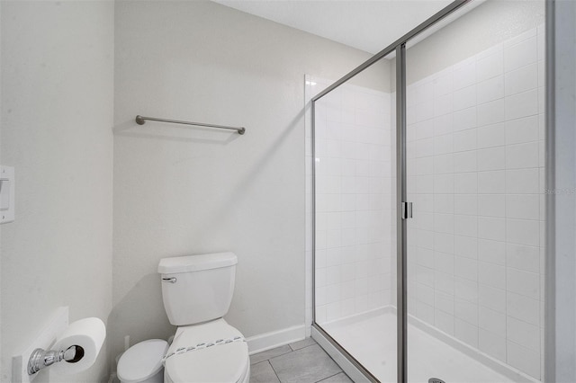 bathroom with walk in shower, tile patterned flooring, and toilet