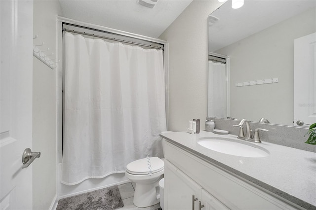 full bathroom featuring tile patterned floors, shower / bath combo, vanity, and toilet