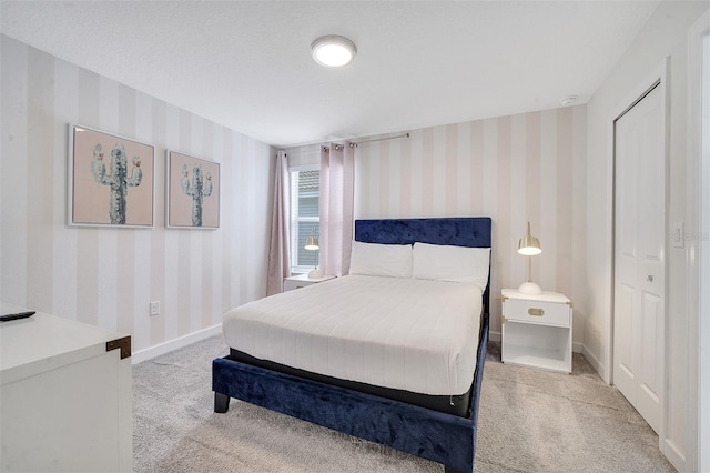 bedroom featuring light carpet and a textured ceiling