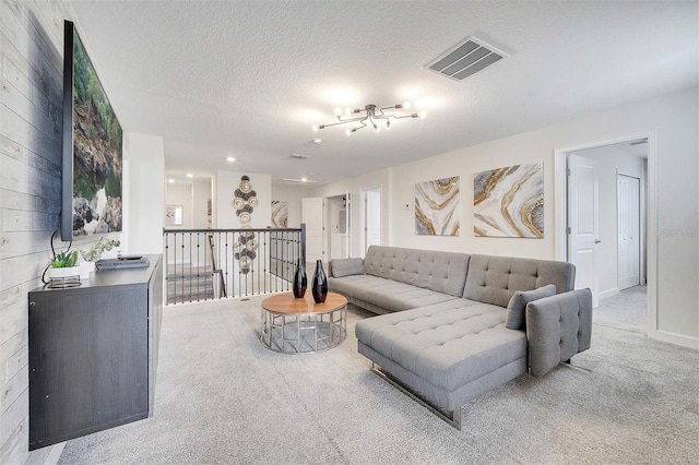 carpeted living room featuring wooden walls and a textured ceiling