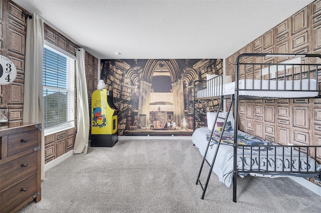 carpeted bedroom featuring wood walls and a textured ceiling