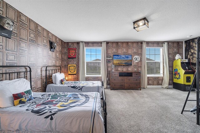 bedroom featuring a textured ceiling, multiple windows, and light carpet