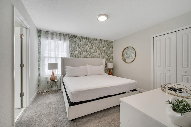 carpeted bedroom featuring a closet and a textured ceiling